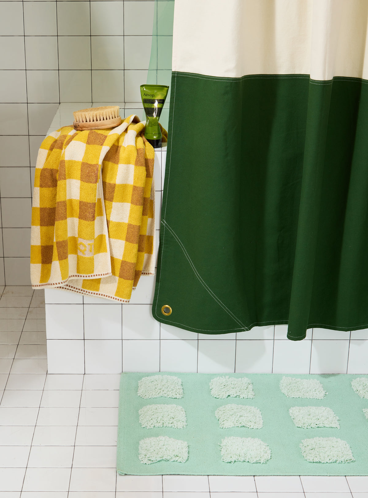 Bottom corner detail of orient pine colorblock shower curtain with brass grommet.