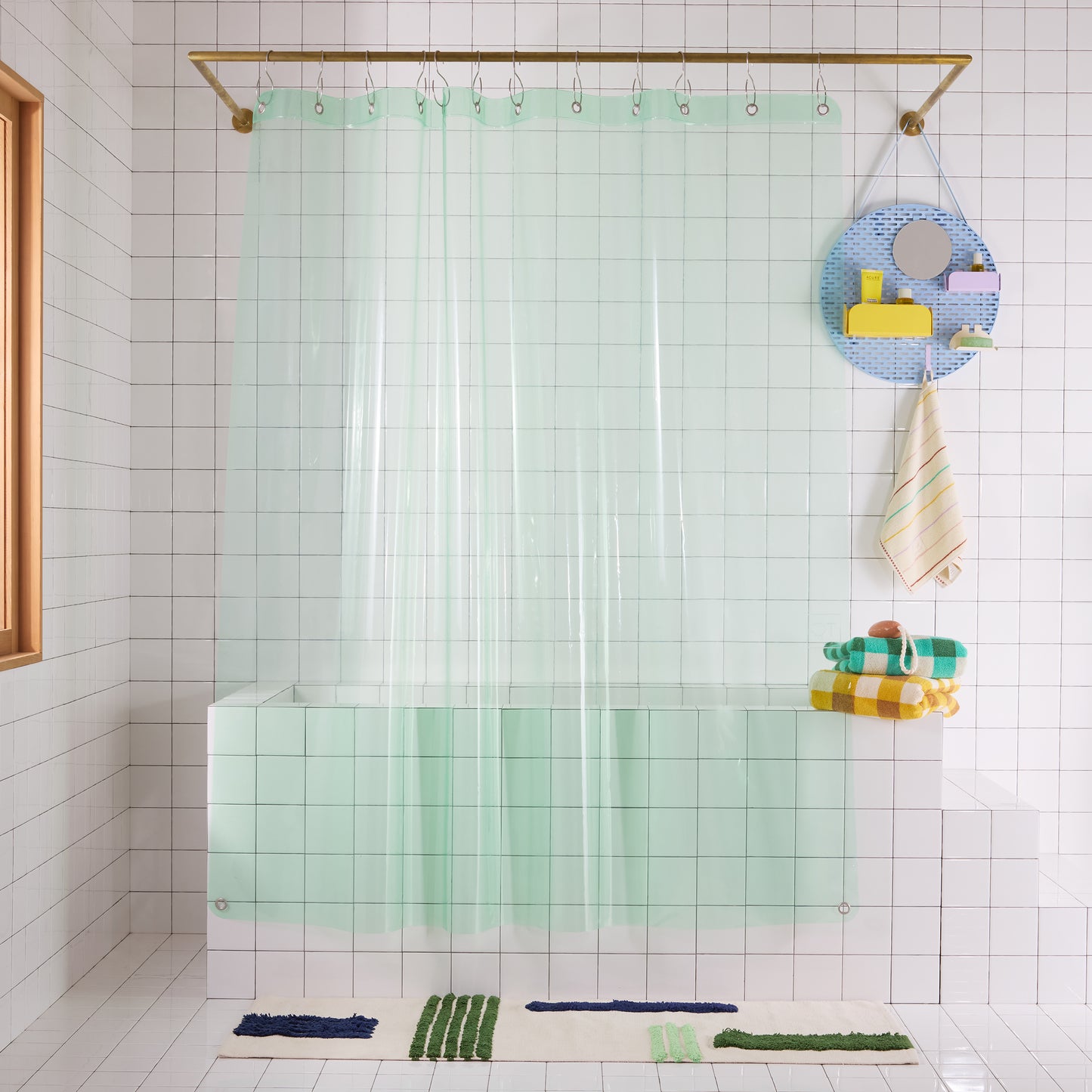 transparent mint green shower curtian hanging in white bathroom
