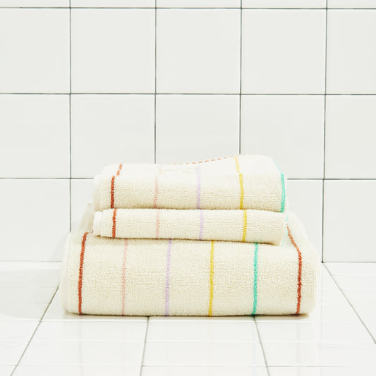 Stack of folded towels with colorful stripes on a tiled floor