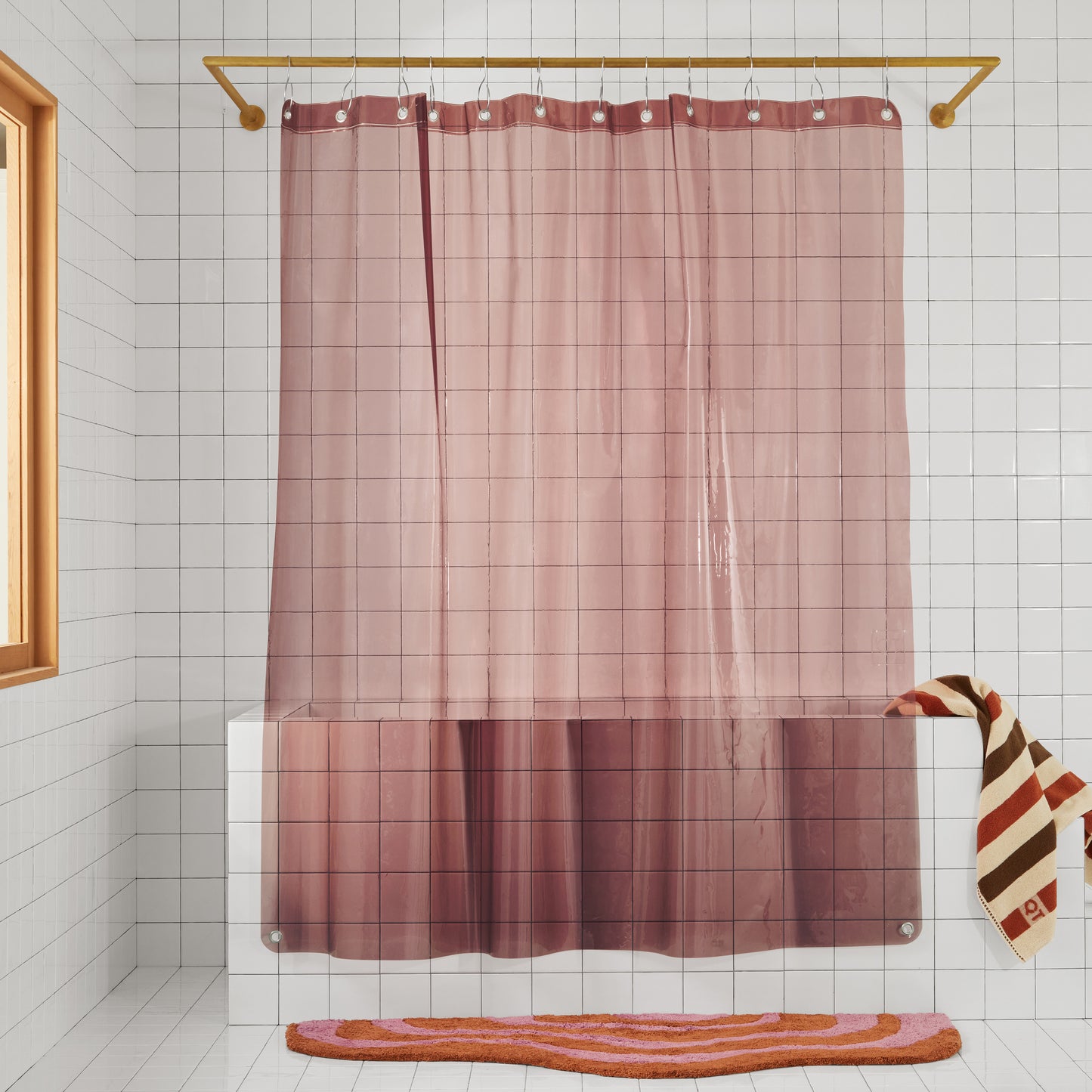 transparent plum colored shower curtain hanging in the white bathroom. 