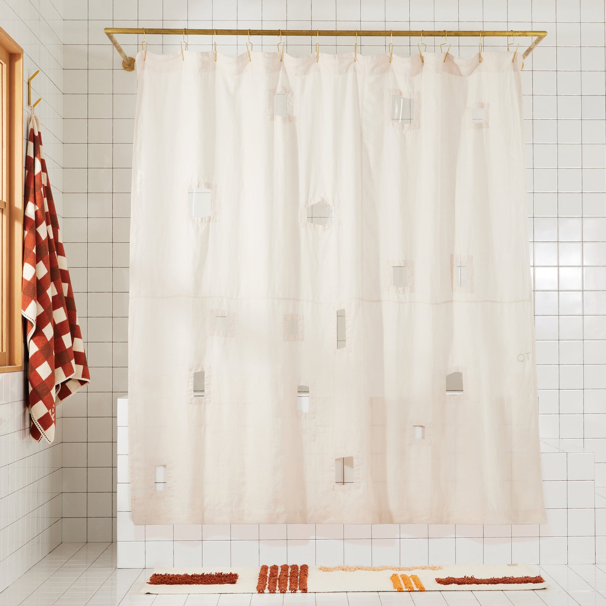 Cream shower curtain with geometric cut outs in a bathroom setting