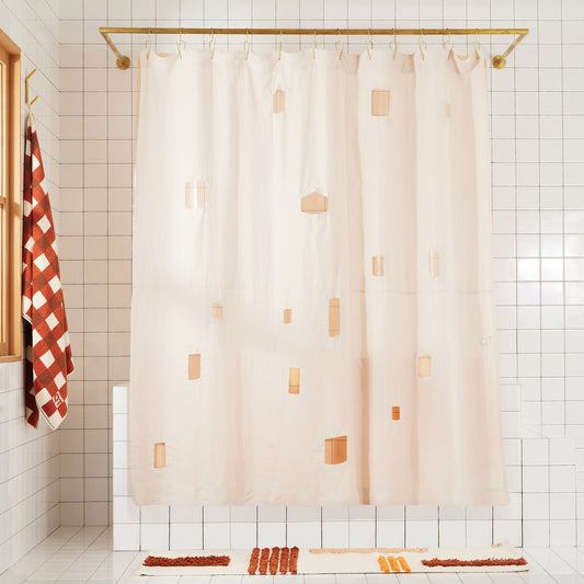 Cream shower curtain with geometric cut outs in a bathroom setting