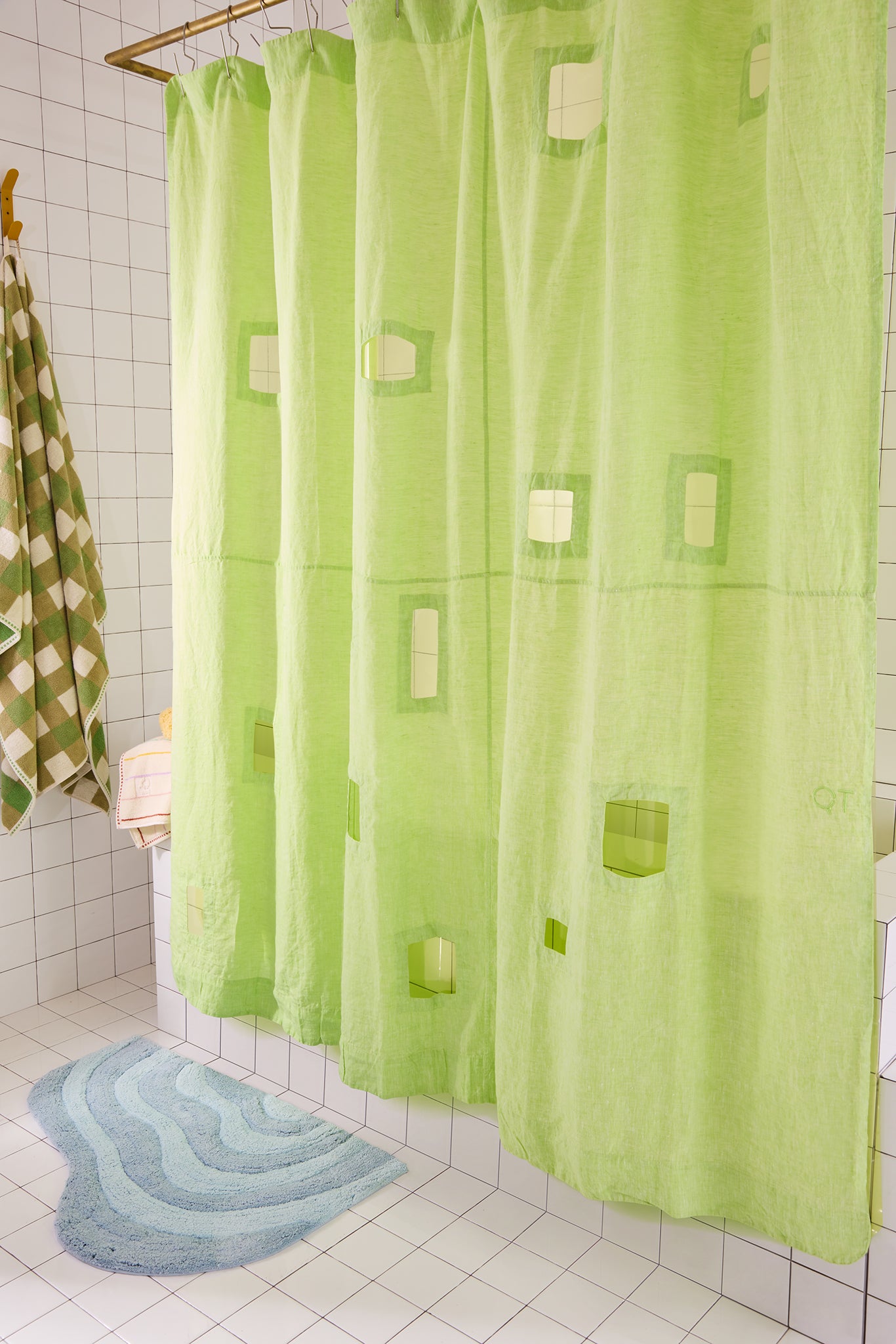 bright green shower curtain with cut outs in a white tiled bathroom.