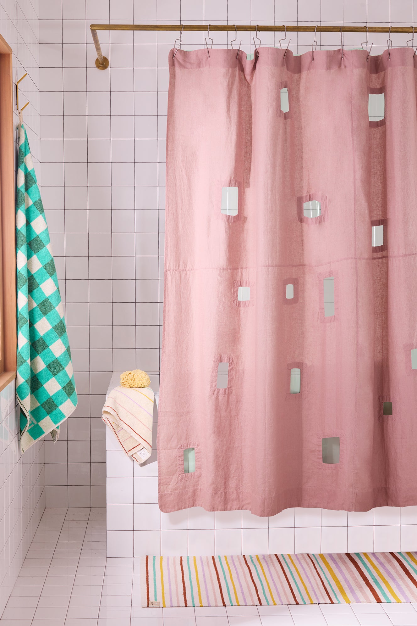 Pink shower curtain with geometric cut outs in a bathroom setting