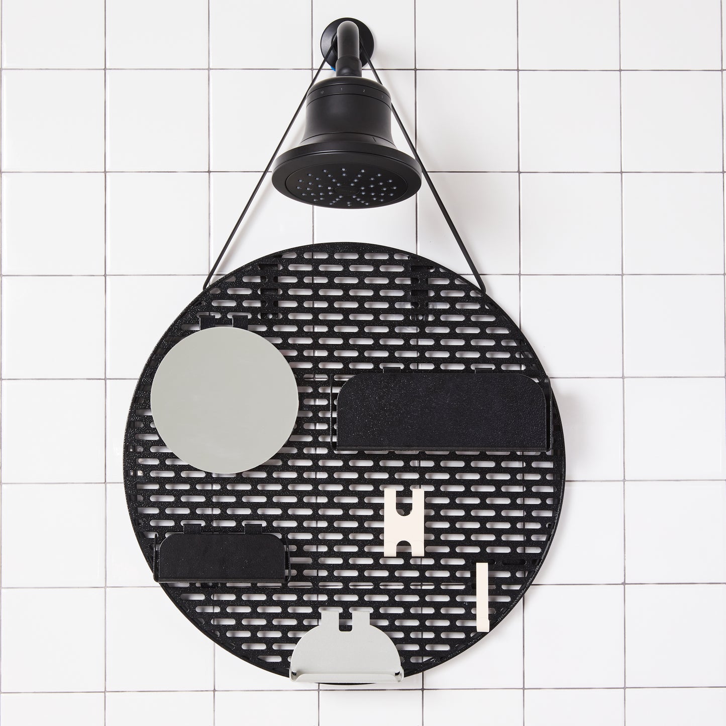 The spot modular shower organizer with shelving pieces arranged hanging in a white tiled shower.