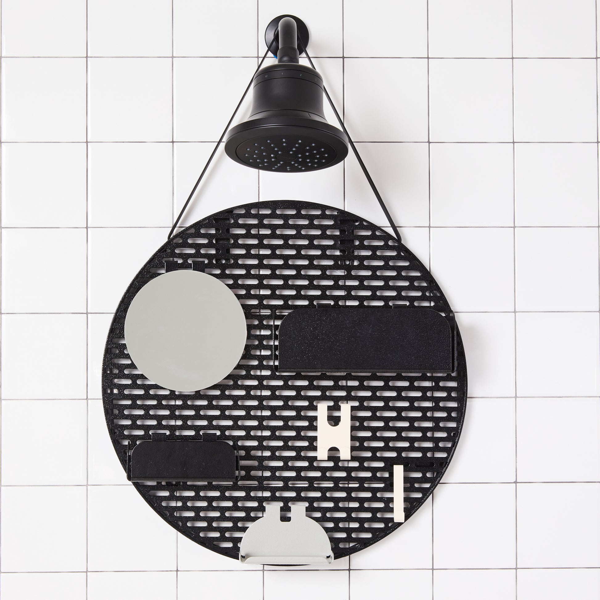The spot modular shower organizer with shelving pieces arranged hanging in a white tiled shower.