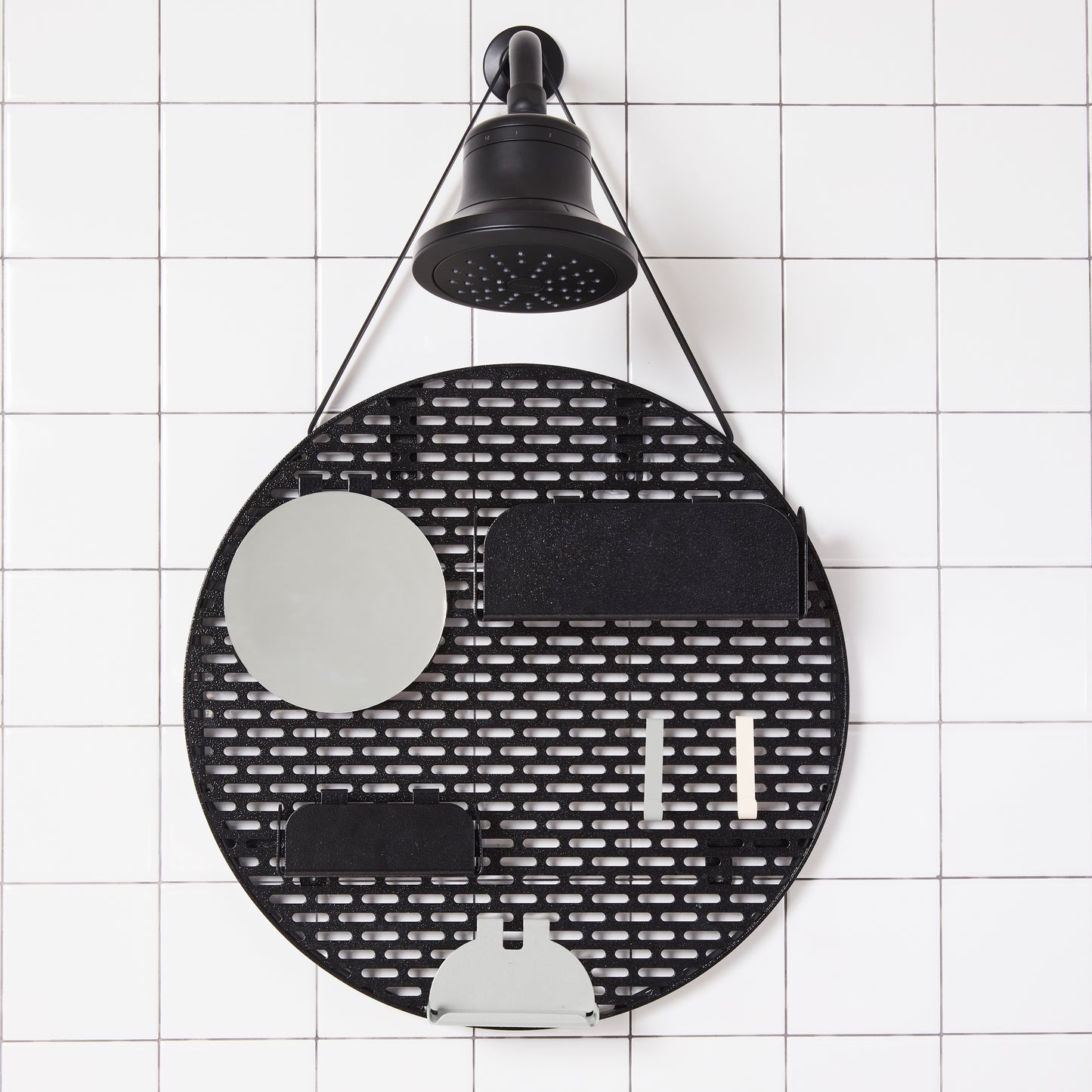 The spot modular shower organizer with shelving pieces arranged hanging in a white tiled shower.
