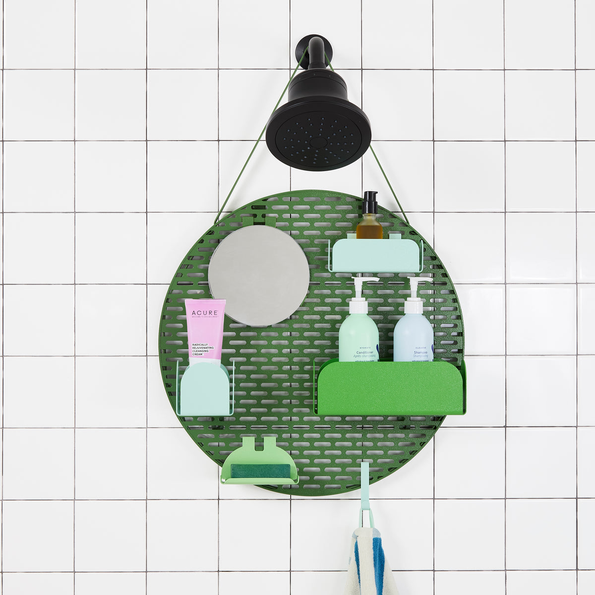 The spot modular shower organizer with shelving pieces arranged and holding products, hanging in a white tiled shower.