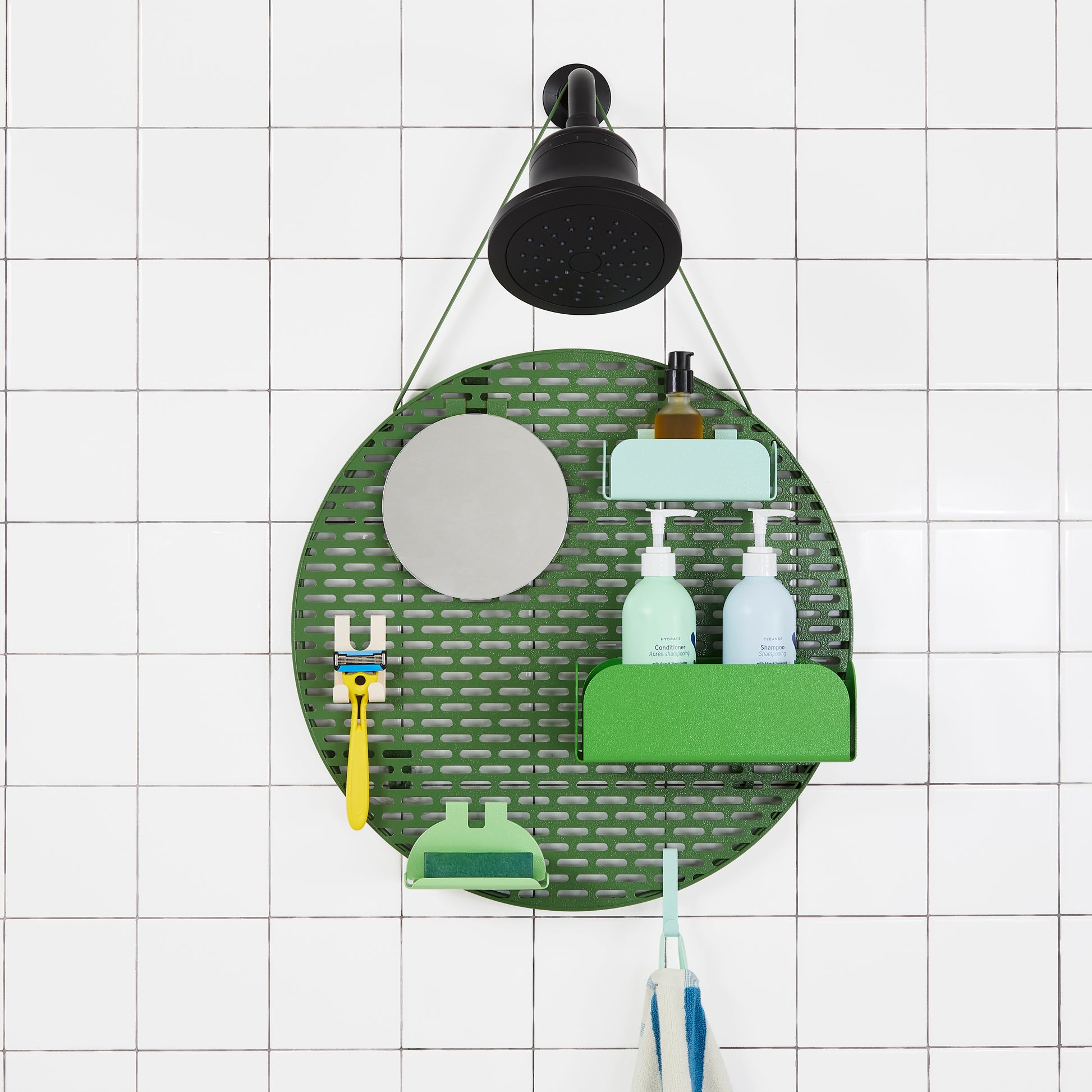 The spot modular shower organizer with shelving pieces arranged and holding products, hanging in a white tiled shower.