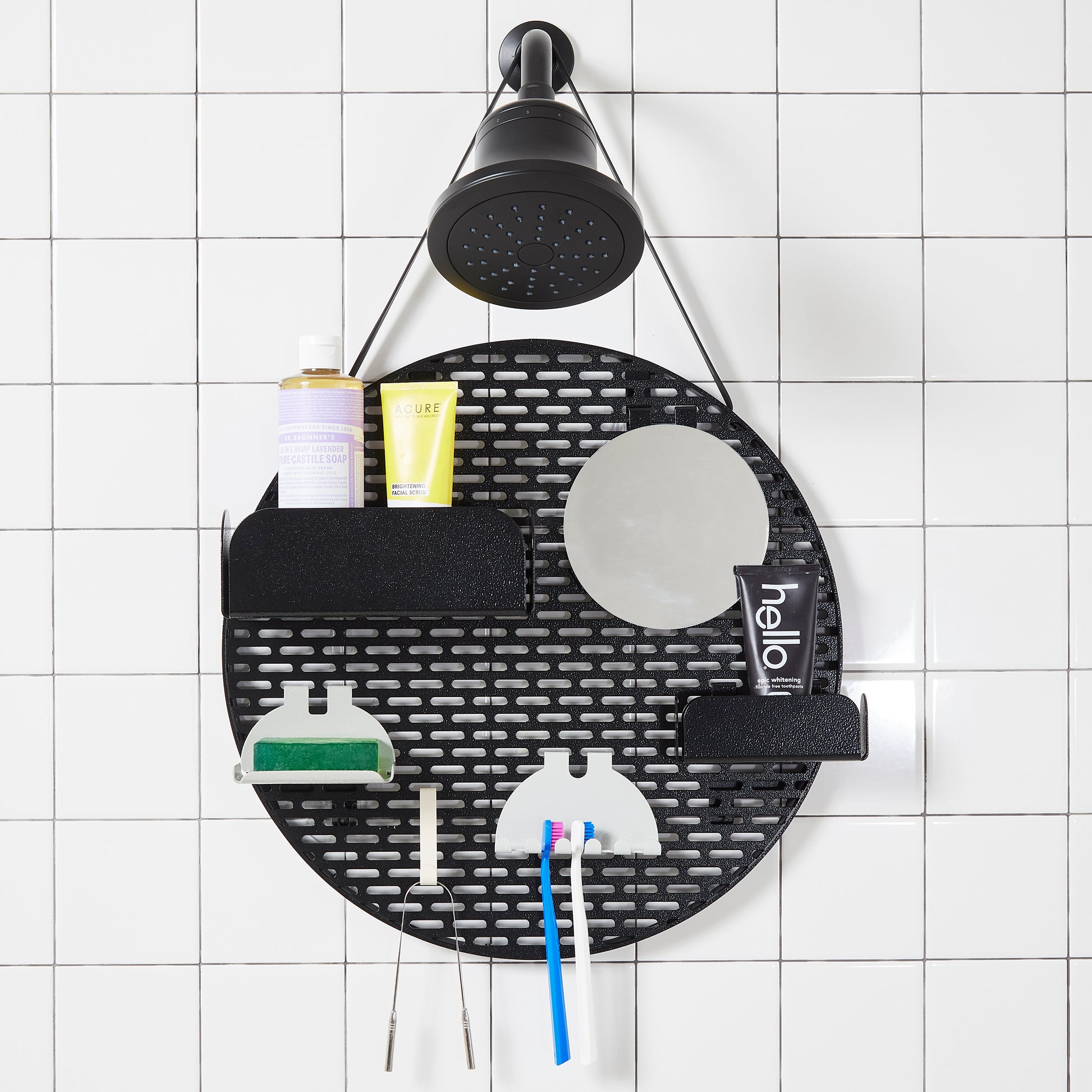 The spot modular shower organizer with shelving pieces arranged and holding products, hanging in a white tiled shower.