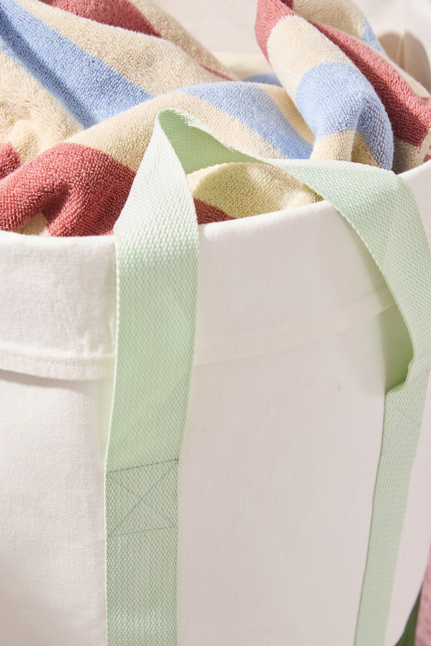 mint green nylon strap with striped towel.