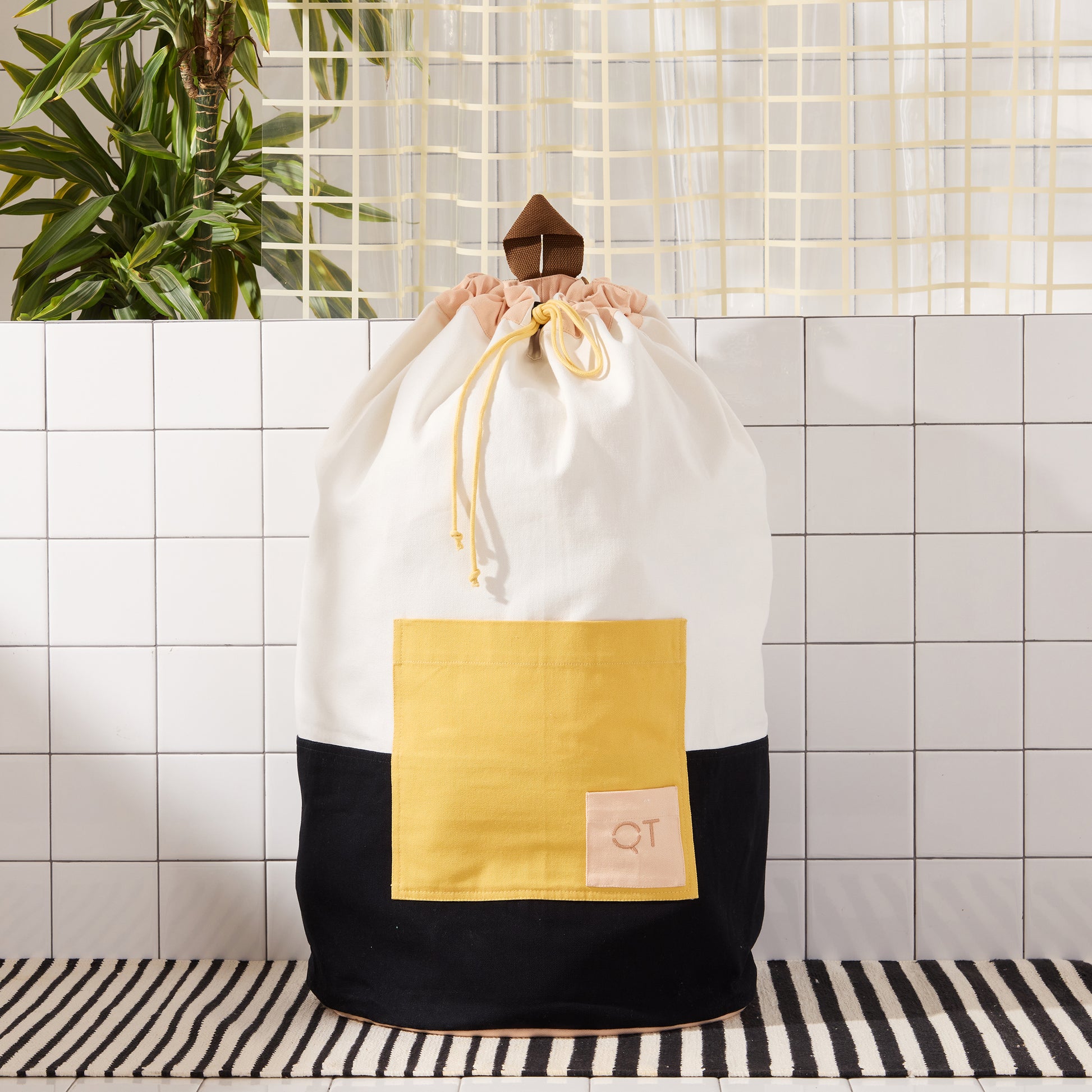 color blocked laundry backpack on striped rug.