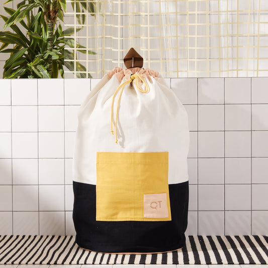 color blocked laundry backpack on striped rug.