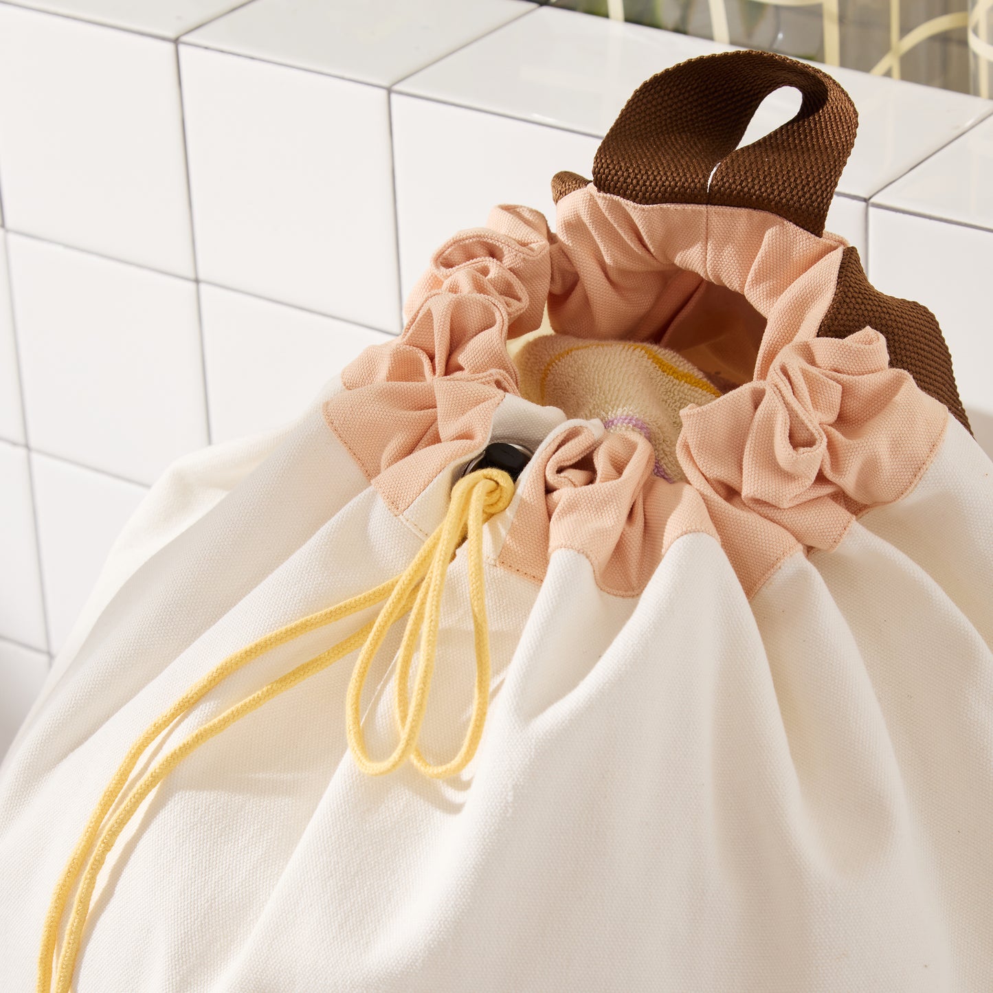 cinched opening of bag with peach and yellow closure. 