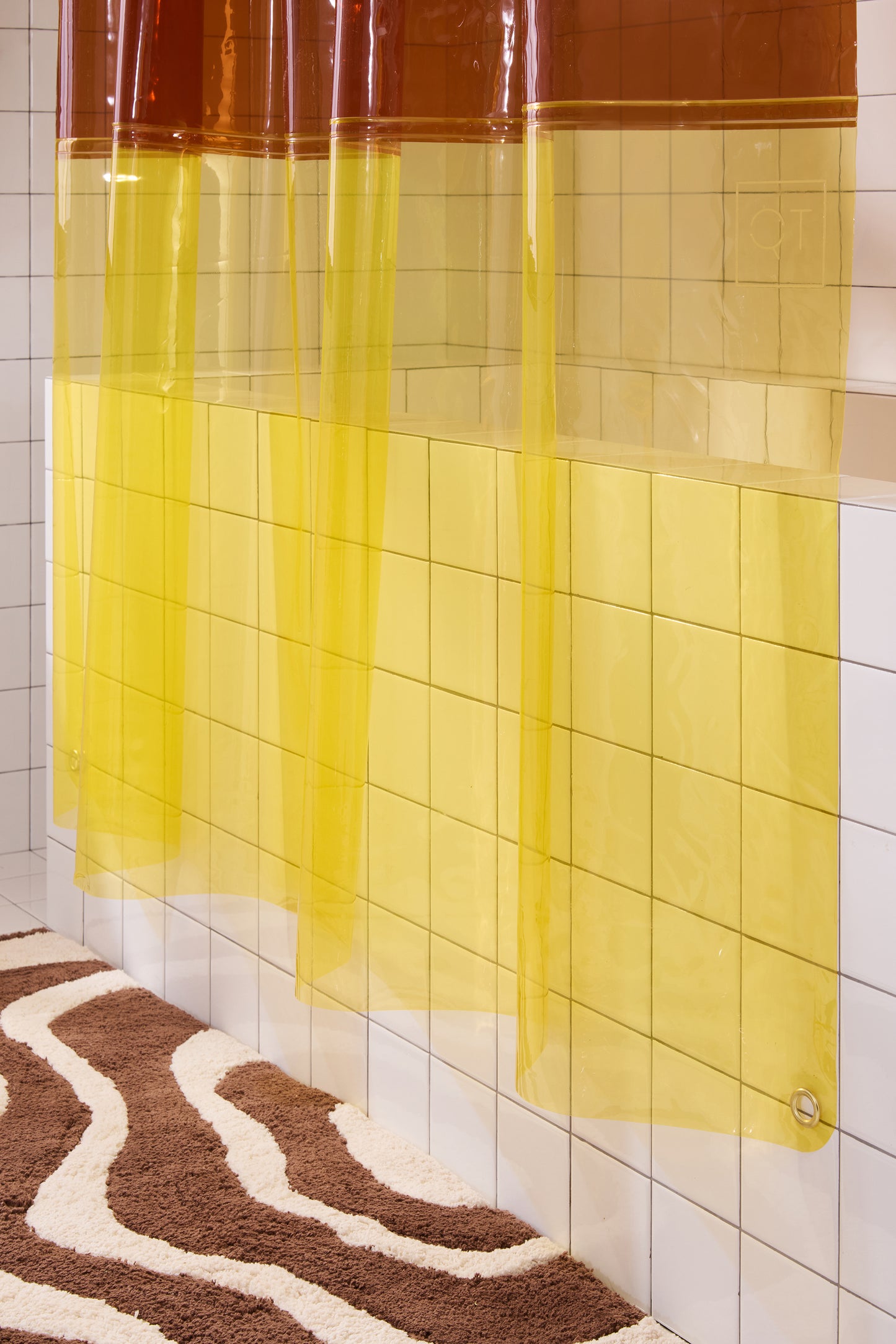 Bottom portion of orient sun shower curtain in cheetah hanging above chocolate lost coast rug. 