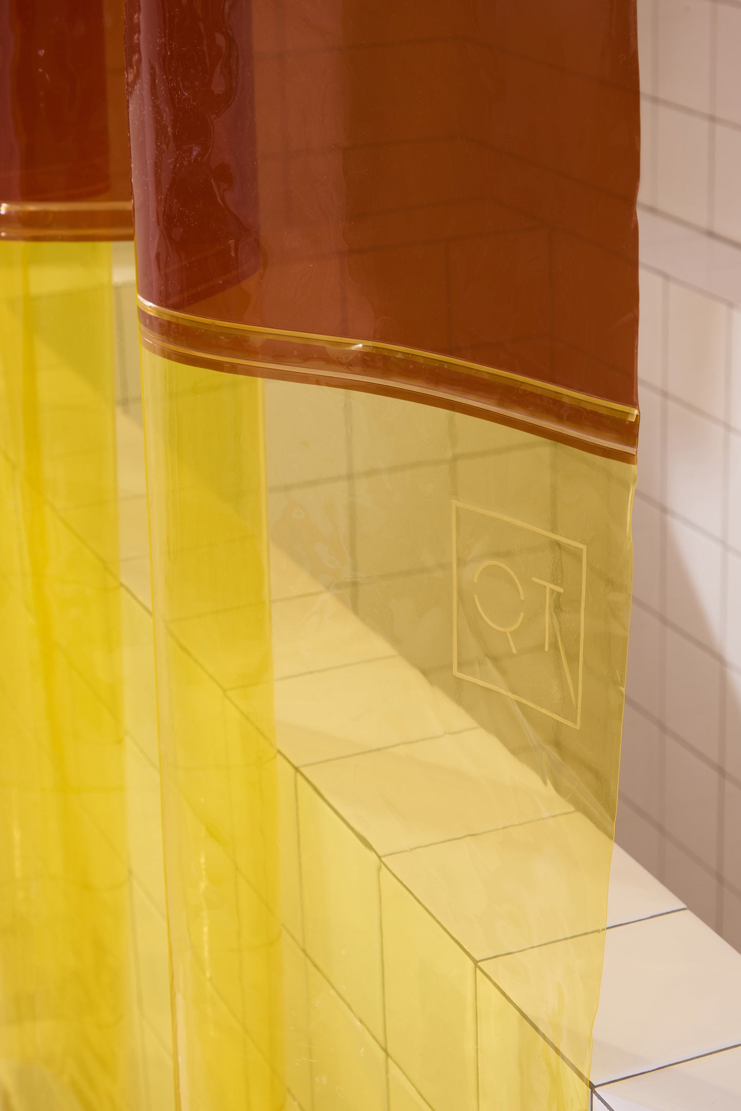 QT logo embossed on color blocked orient sun shower curtain. 