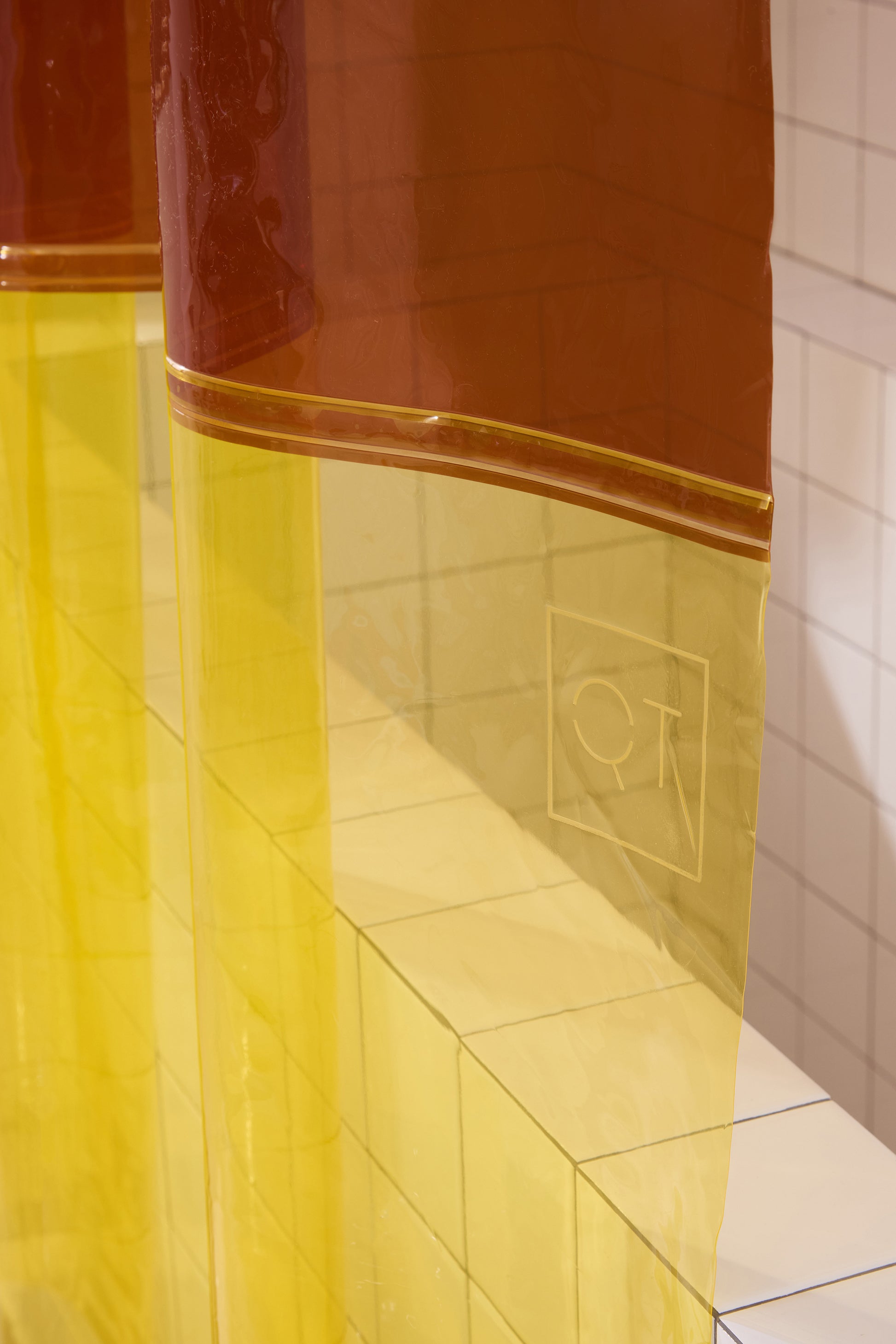 QT logo embossed on color blocked orient sun shower curtain. 