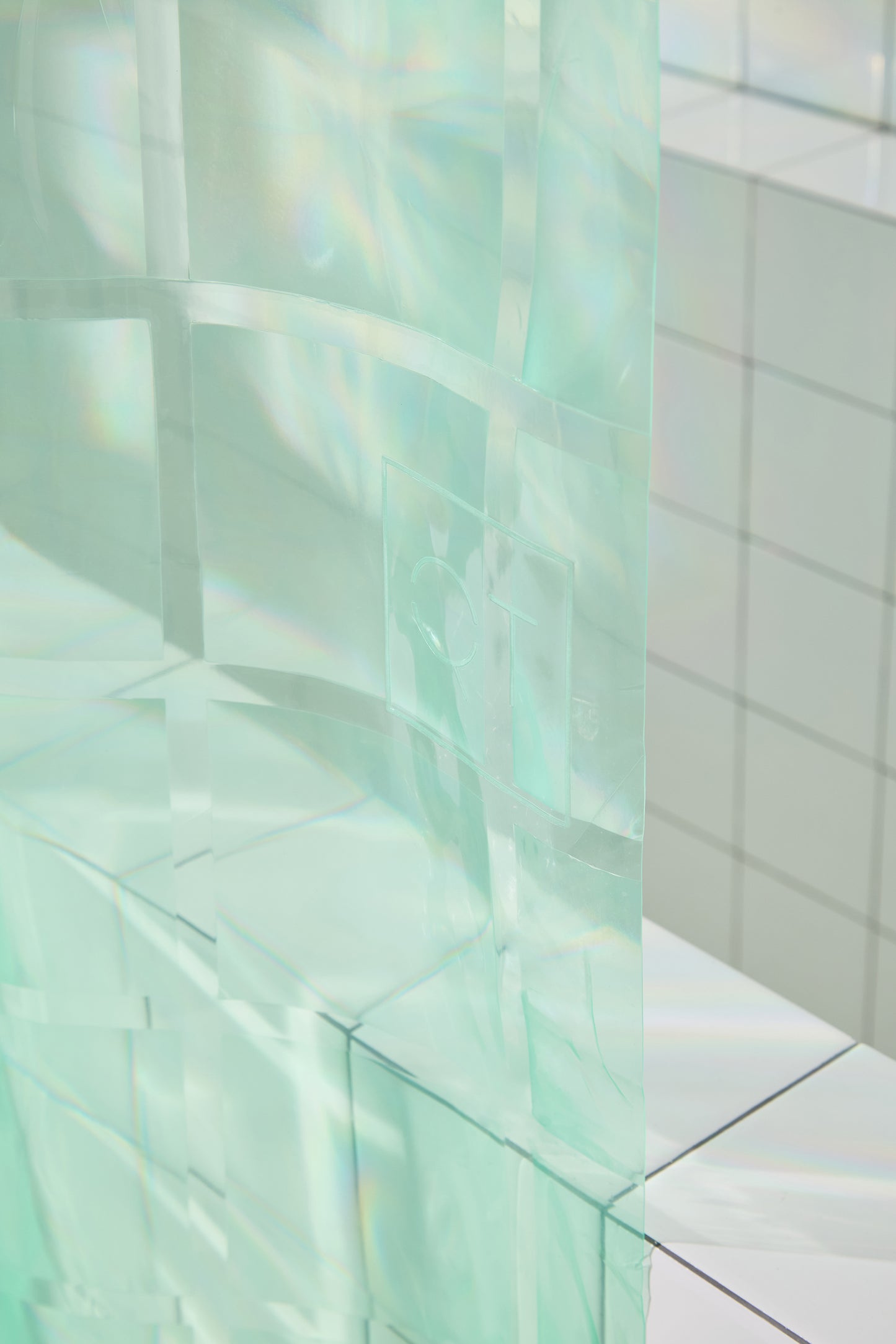 QT logo highlighted in photo of mint colored shower curtain. 
