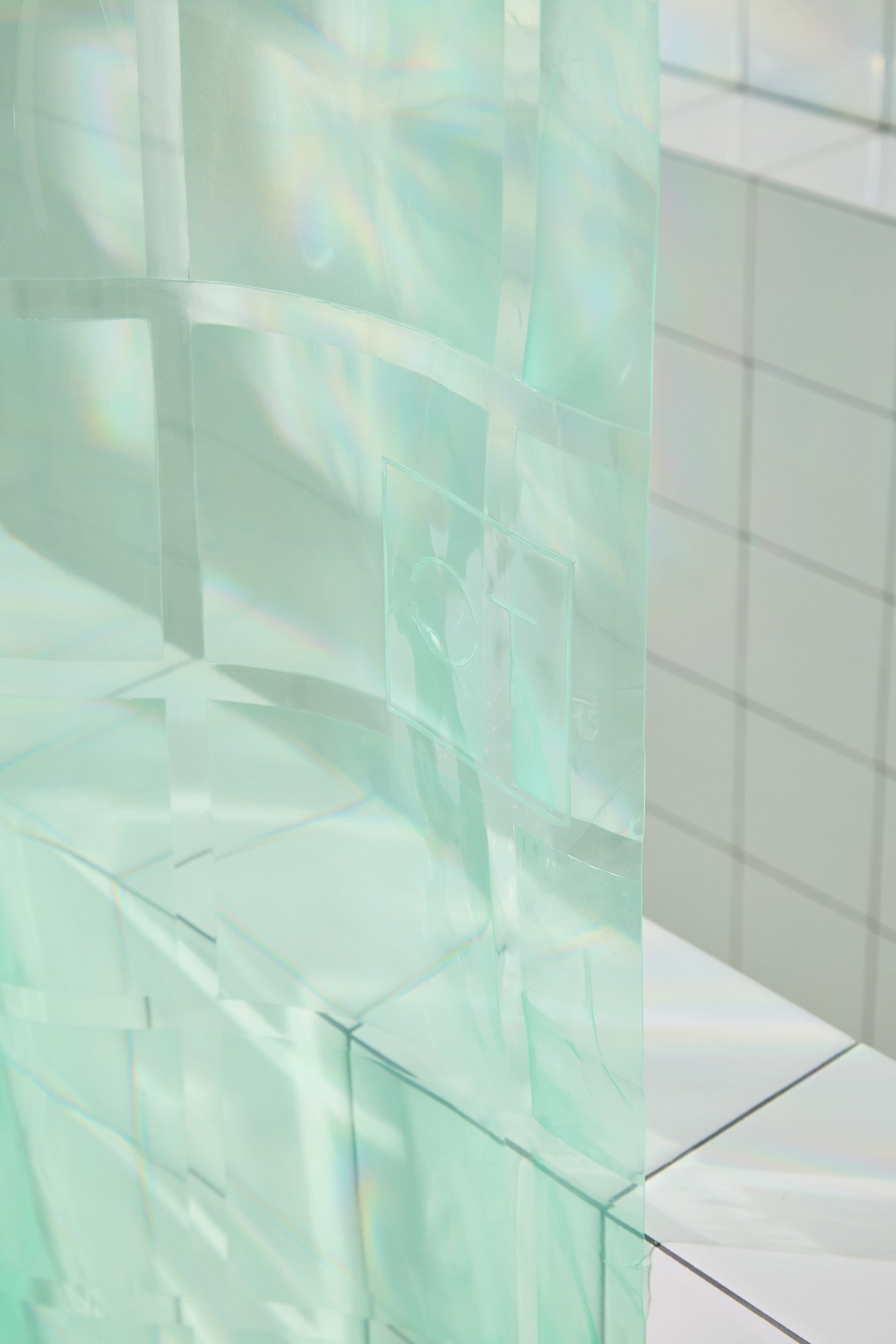 QT logo highlighted in photo of mint colored shower curtain. 