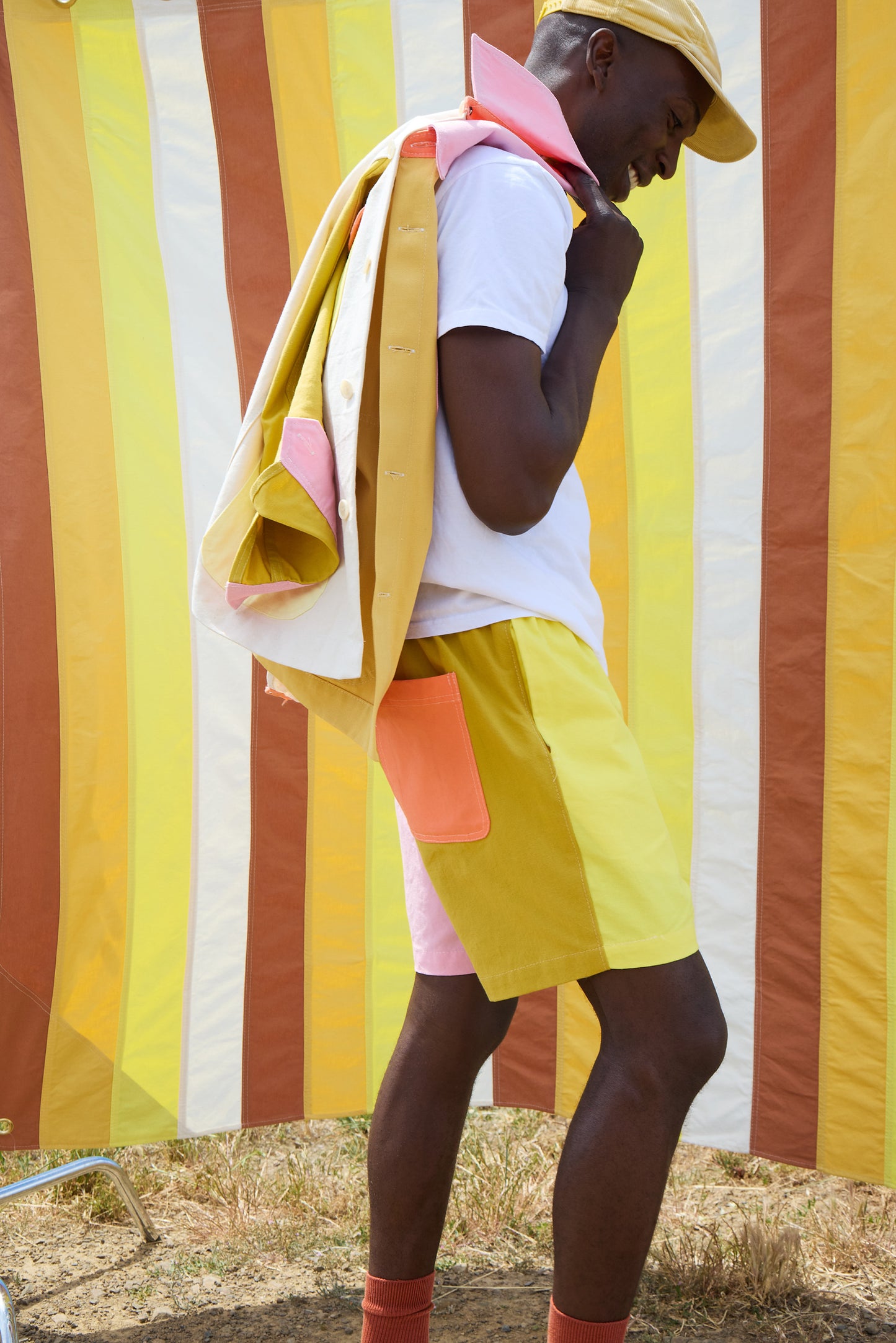 Person wearing a colorful outfit with a striped background