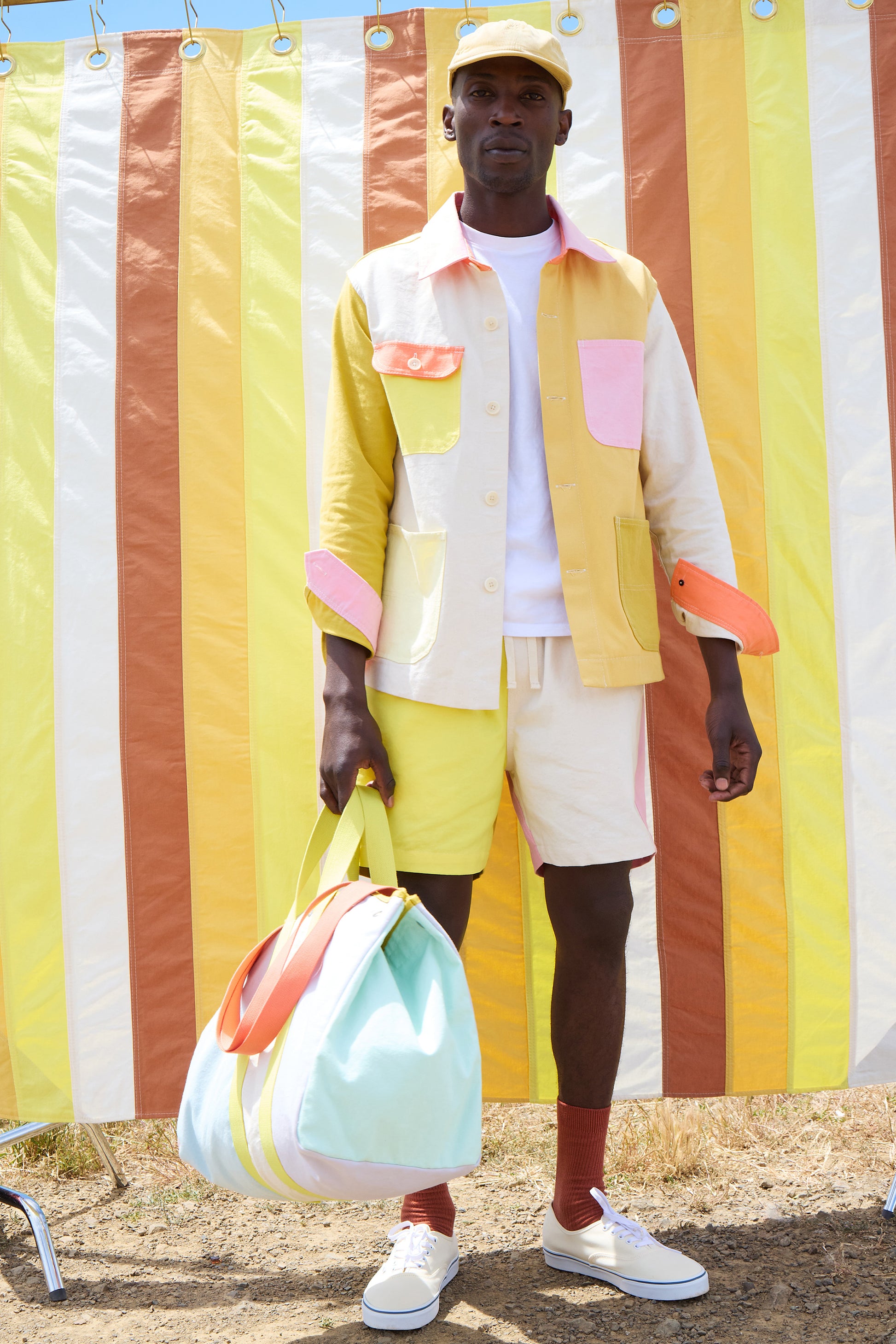 Person wearing a colorful outfit with a striped background