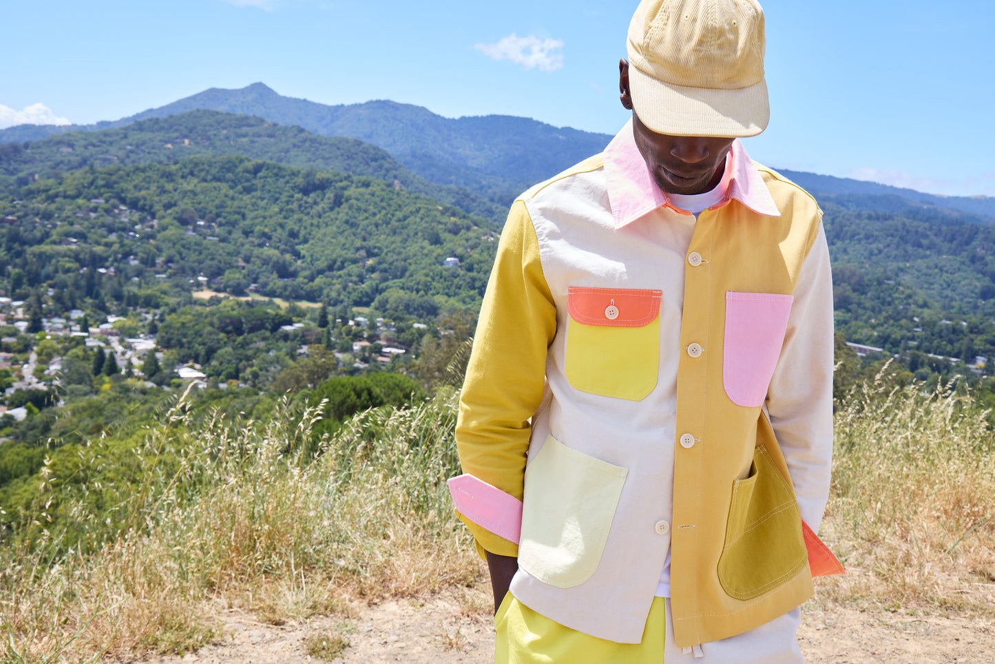 Person wearing a colorful jacket with a mountainous landscape in the background