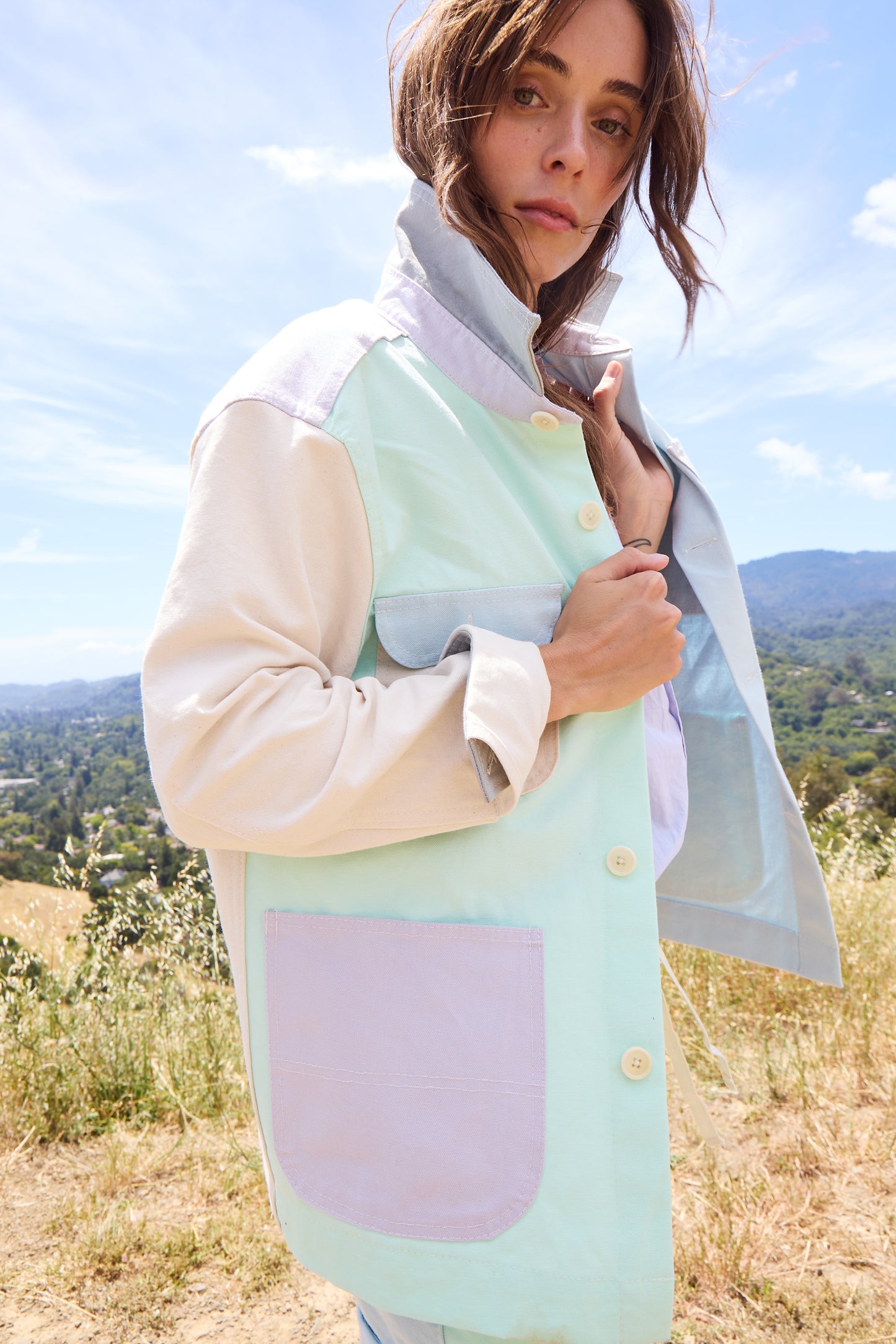 woman wearing colorful jacket on a hillside. 