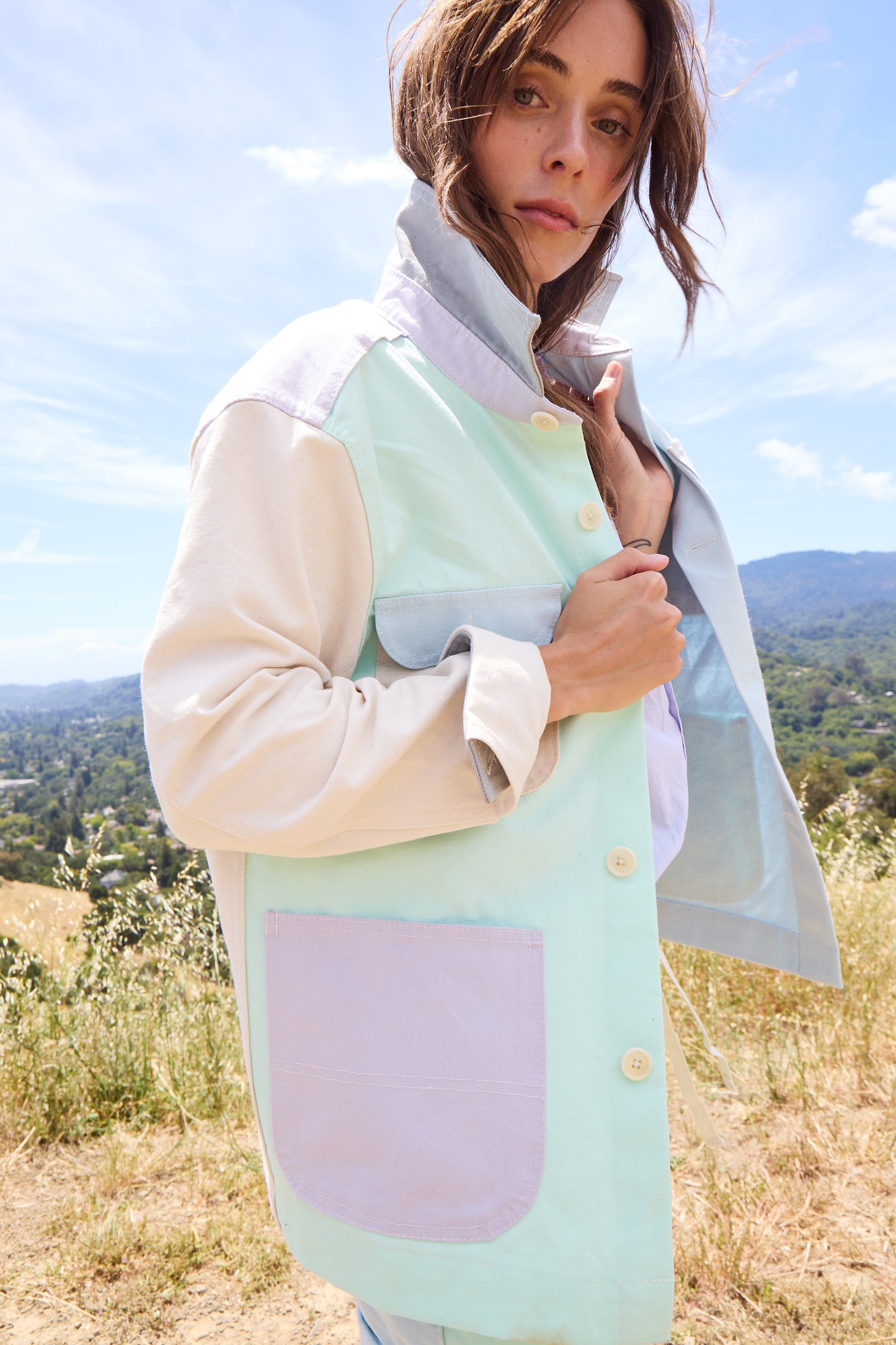 woman wearing colorful jacket on a hillside. 