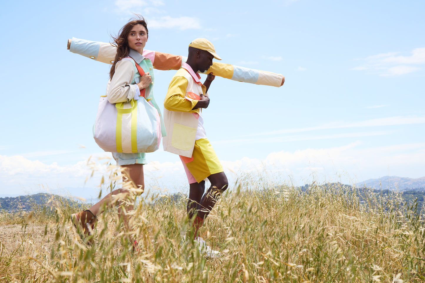 Two people in colorful outfits standing in a field with a clear blue sky.