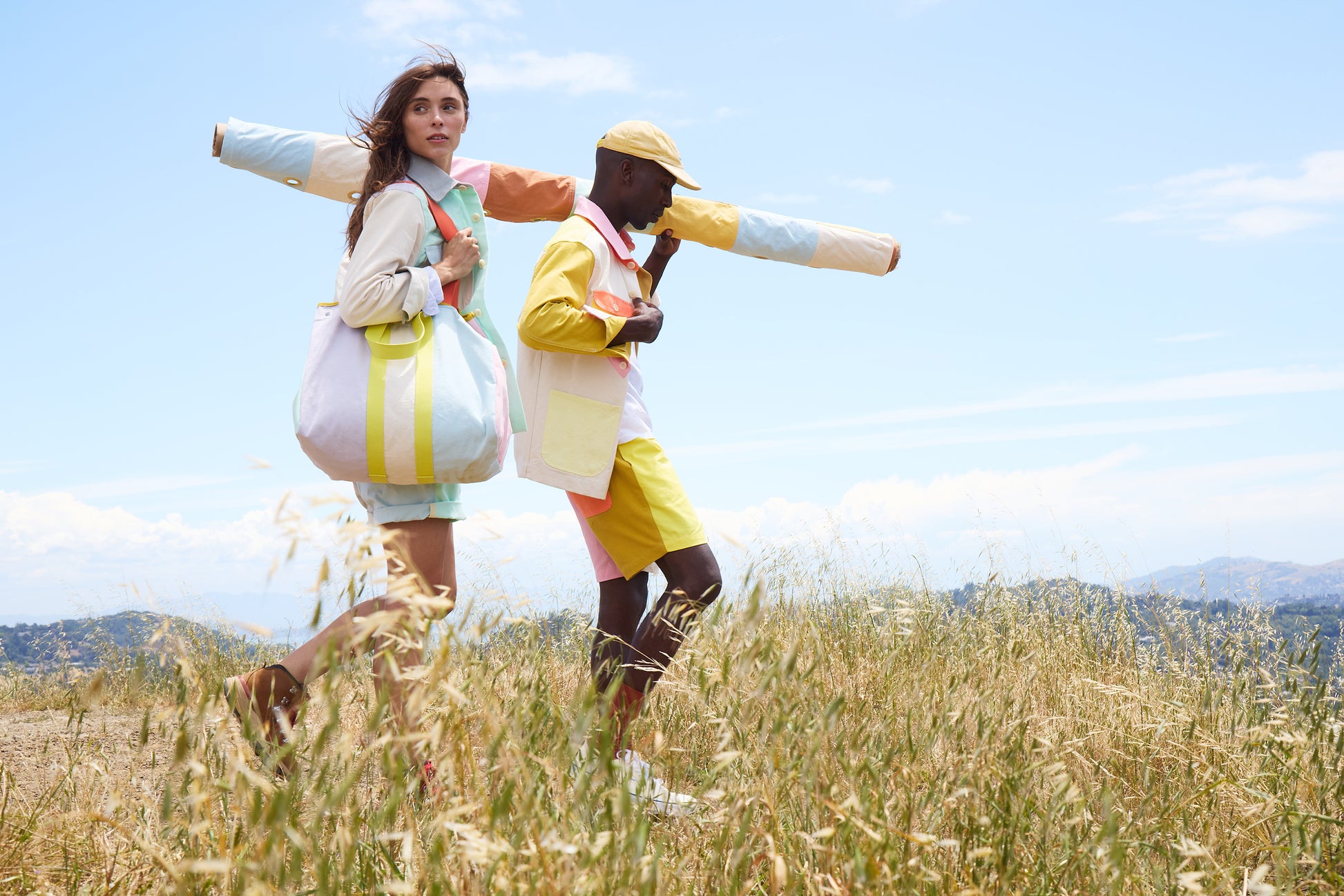 Two people in colorful outfits standing in a field with a clear blue sky.