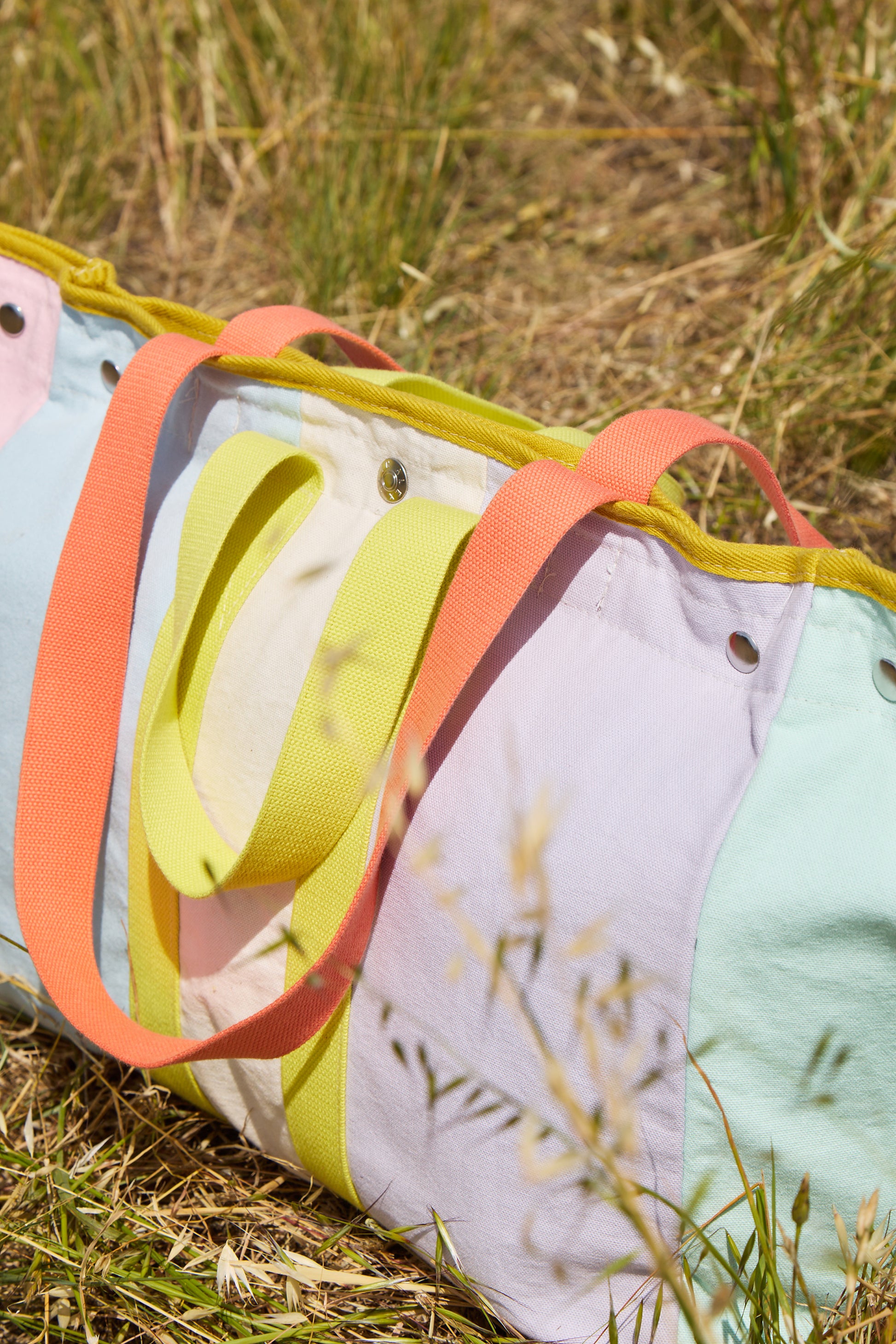 Colorful fabric bag with handles on a grassy background