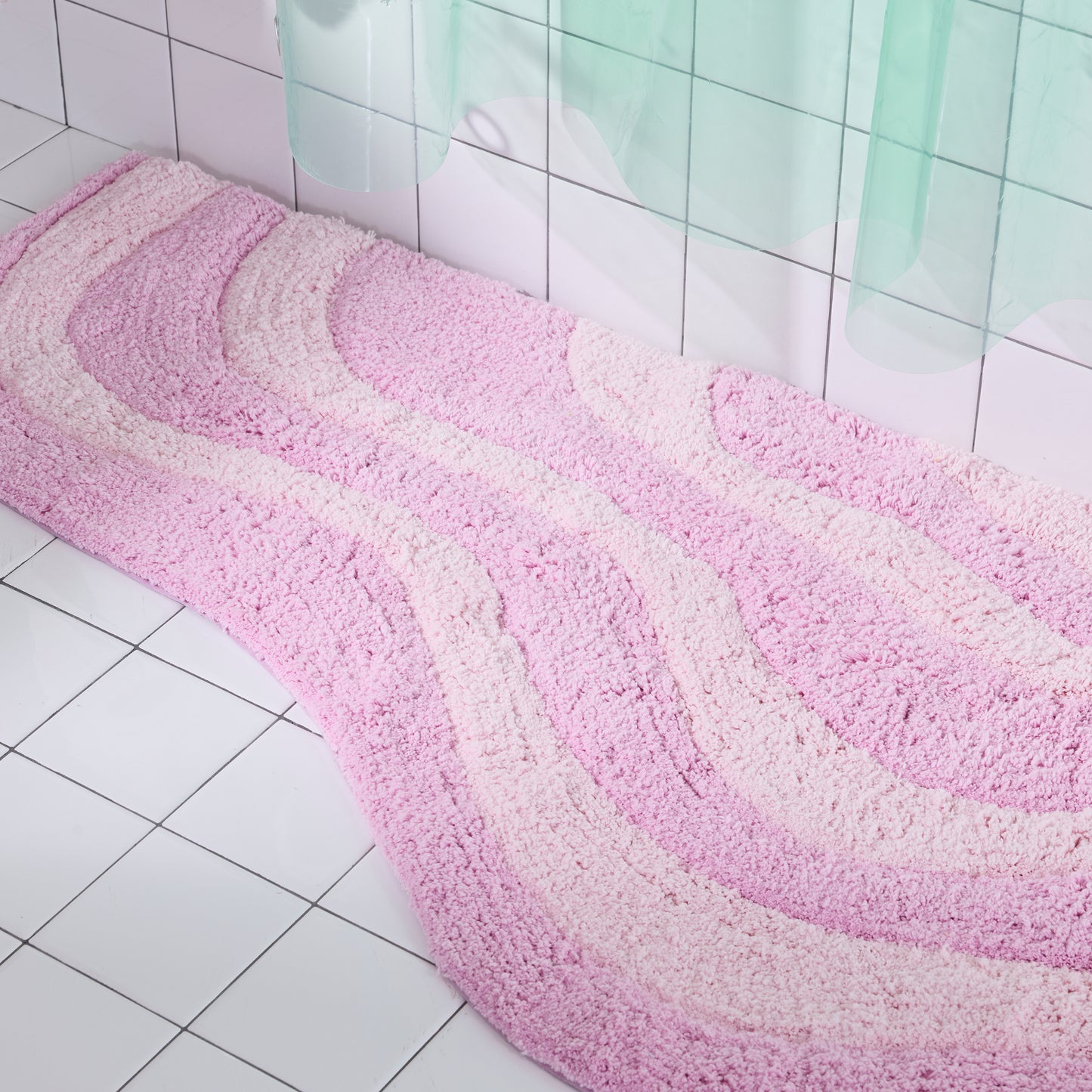 Pink and white bath mat on a tiled bathroom floor