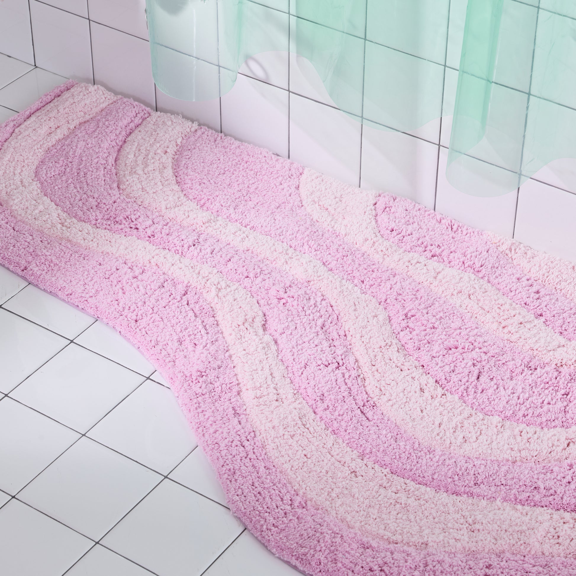 Pink and white bath mat on a tiled bathroom floor