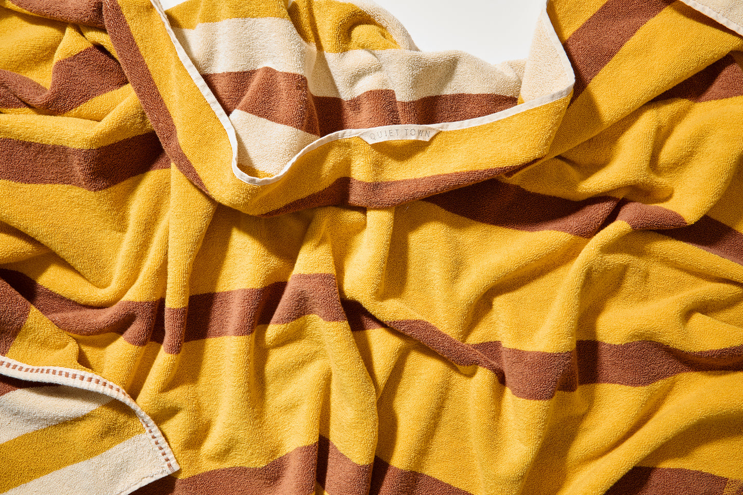 Close up view of catalina bath sheet in canyon featuring color to color stripes in honey and yellow. 