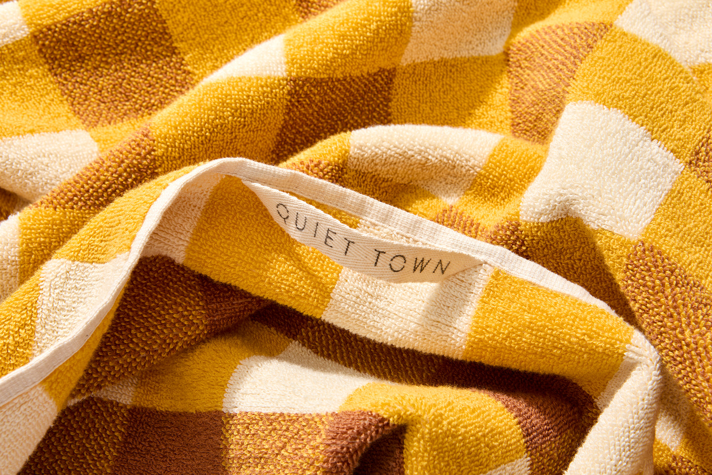 Detail view of tam bath sheet with the Quiet Town hanging loop.