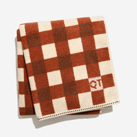 Tam bath sheet in chocolate folded against white background. 