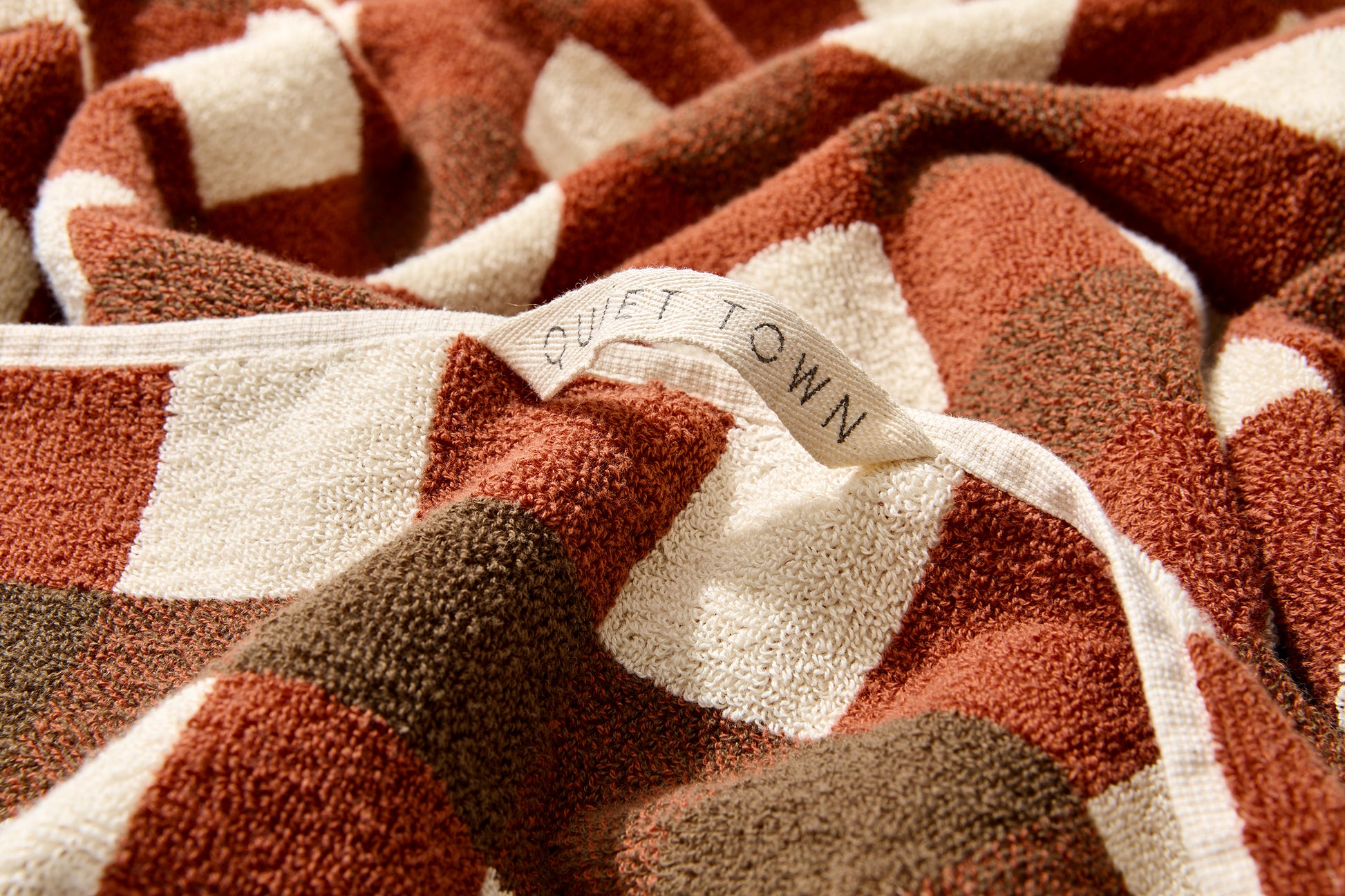 Tam bath sheet in chocolate with Quiet Town hanging loop.