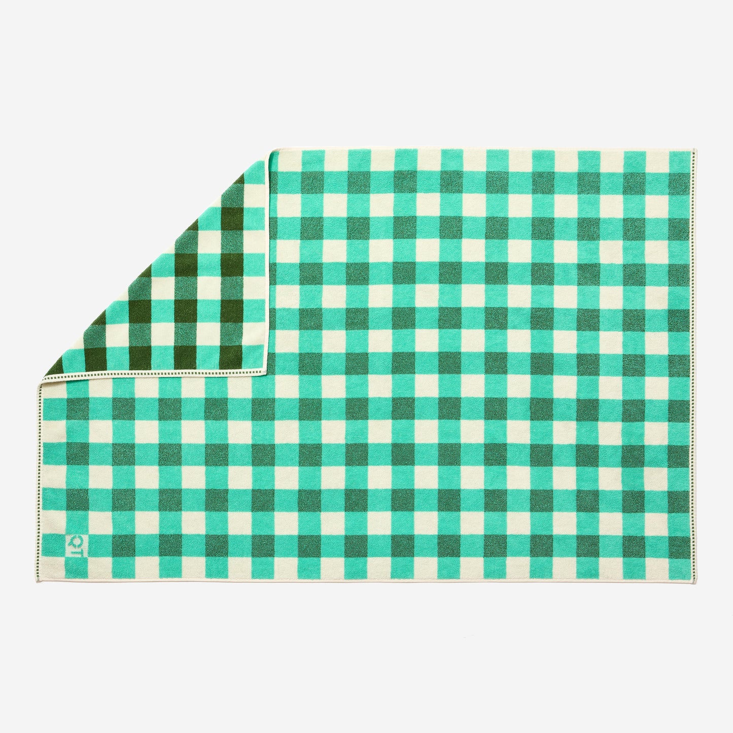 Full view of tam bath sheet in pine laid out with one corner flipped up to show the more saturated side. 