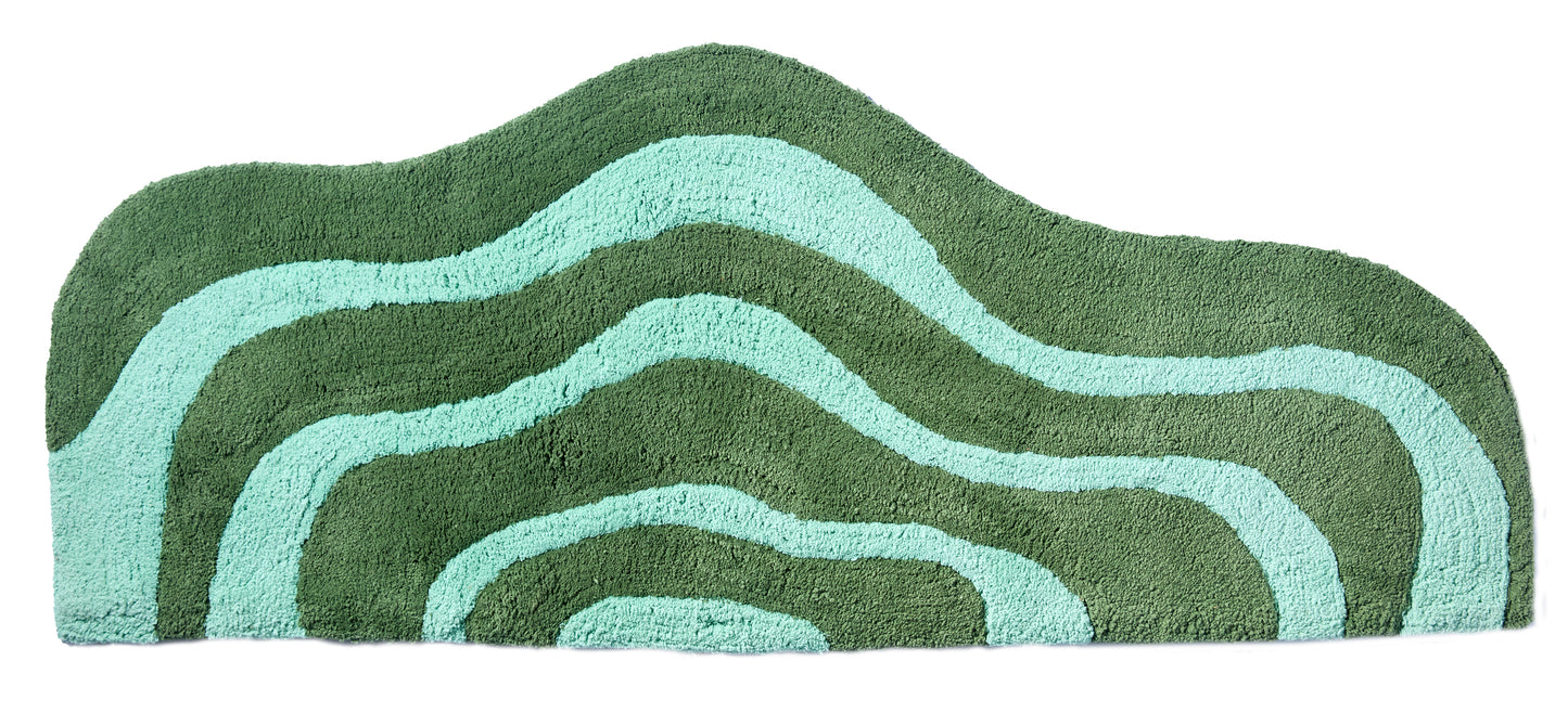 Wave shaped pine and jade striped bath mat runner in 56"x22" size with white background. 