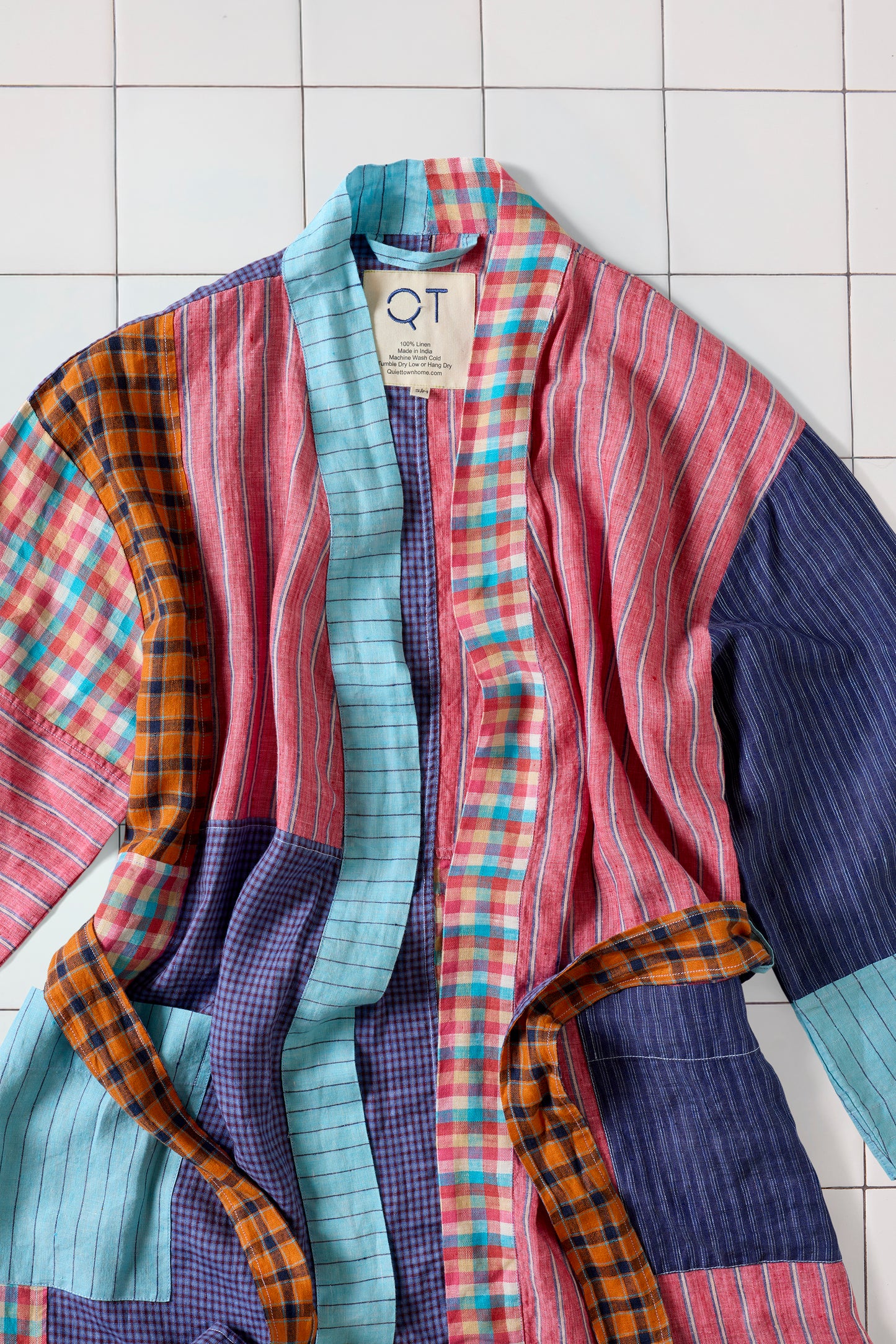 Colorful patchwork robe with a QT tag on a tiled background