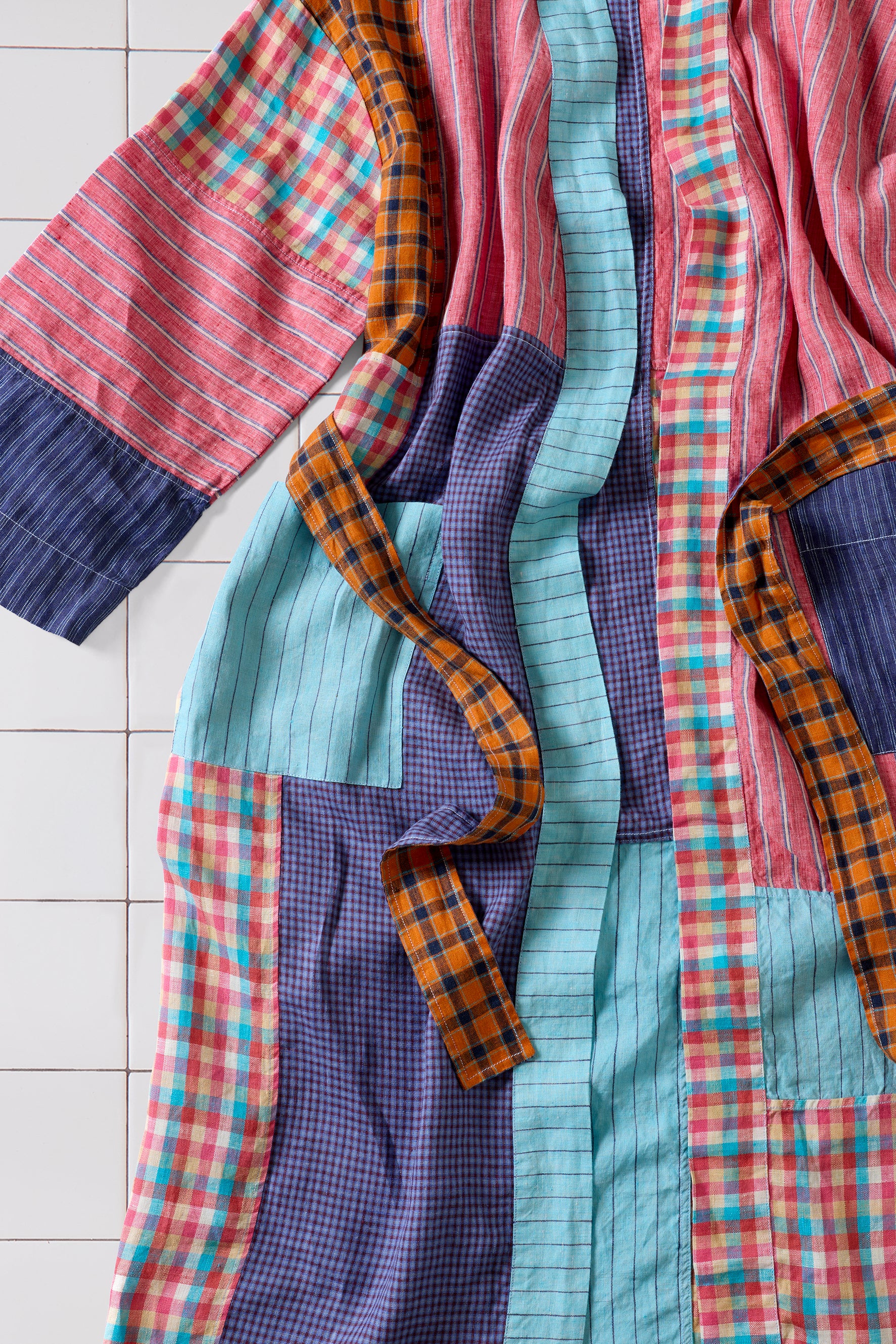  Colorful patchwork fabric robe on a white tiled floor