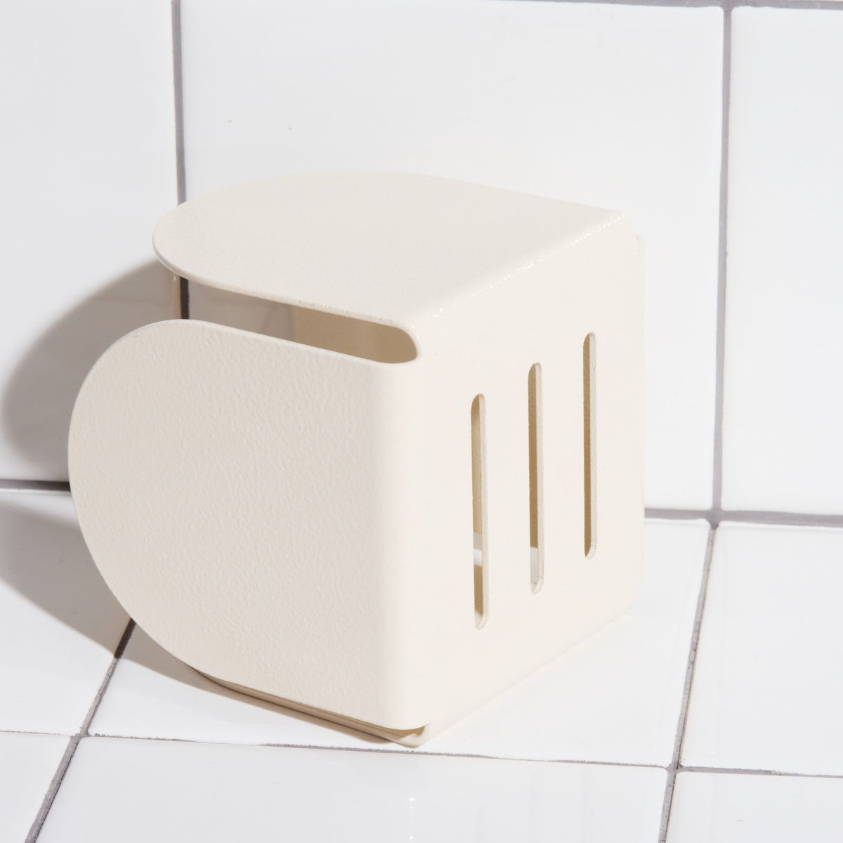 Underside of aluminum basket holder hook in sand.