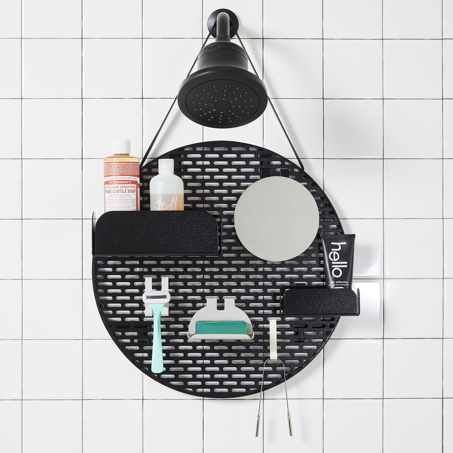 The spot modular shower organizer with shelving pieces arranged and holding products, hanging in a white tiled shower.