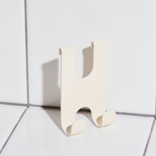 Aluminum razor holder hook in sand.